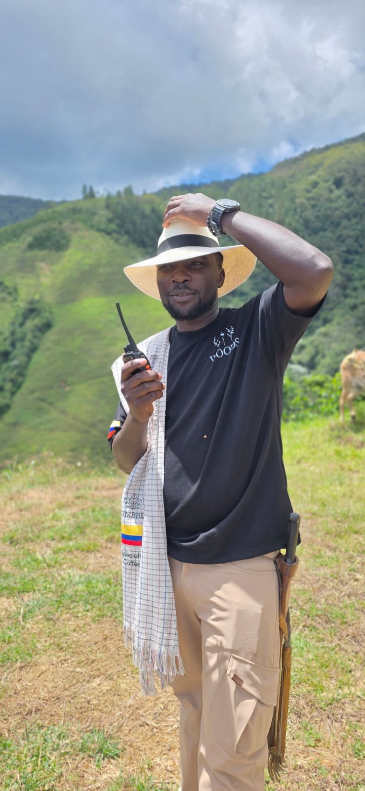 Bonface examining green coffee beside a roaster